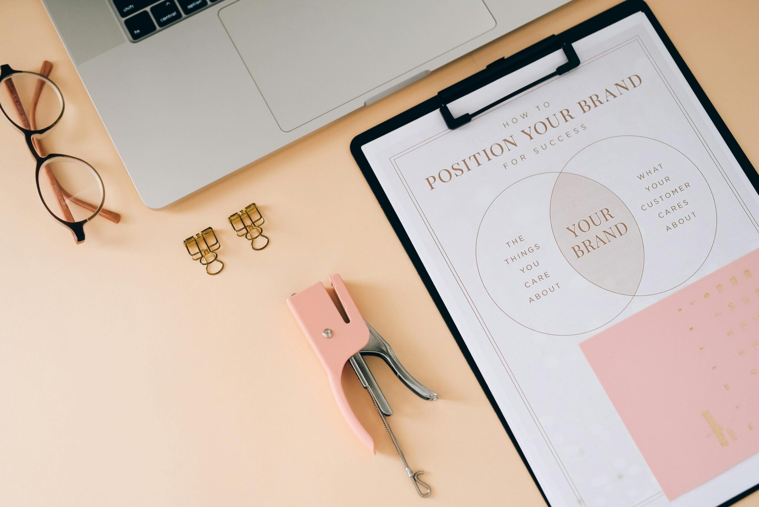 glasses, computer and a clipboard that says position your brand